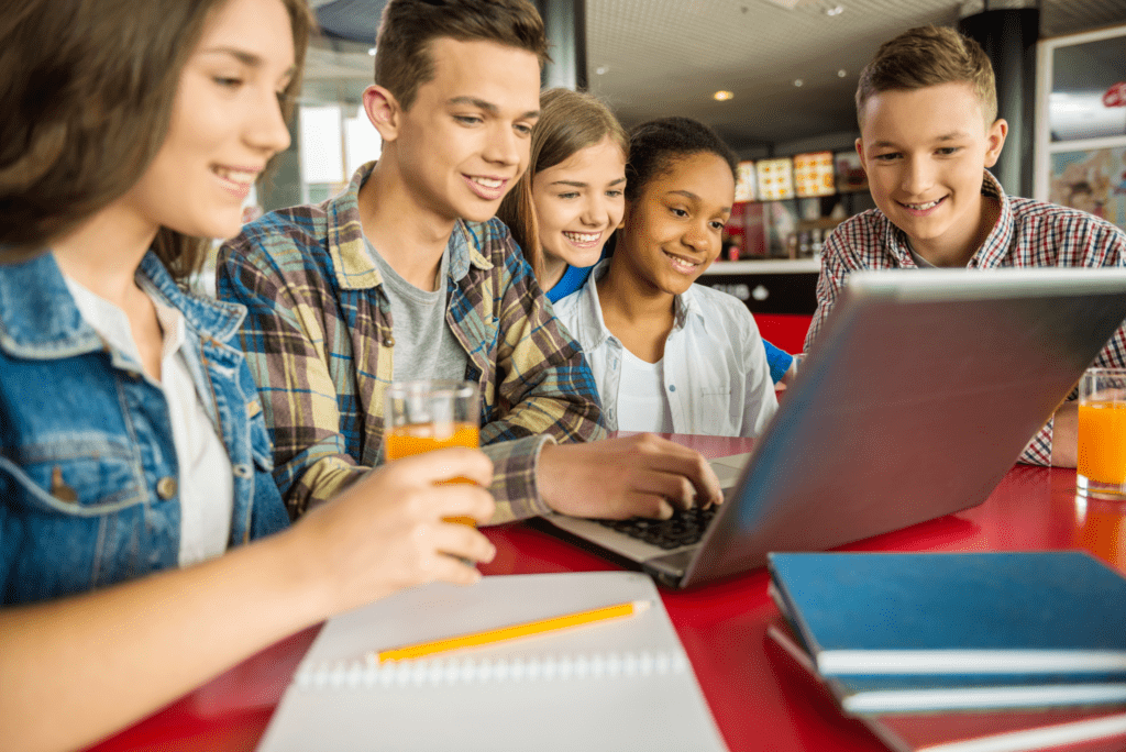a group of kids looking at a laptop