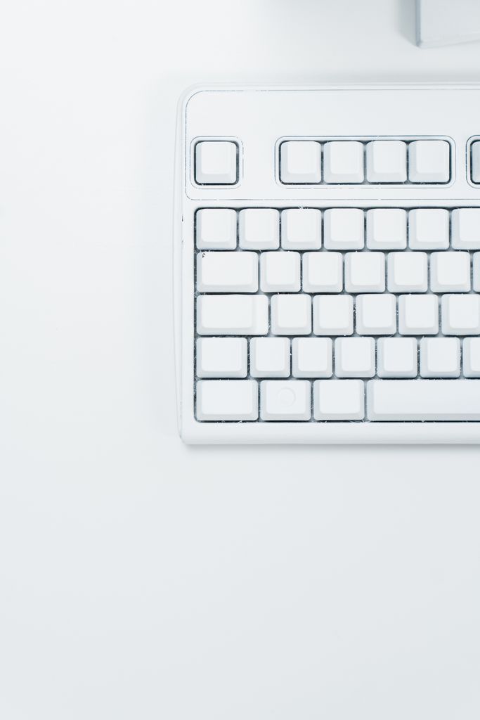 Minimal white keyboard with blank, unlabeled keys on a plain white surface, representing keyboard-only testing