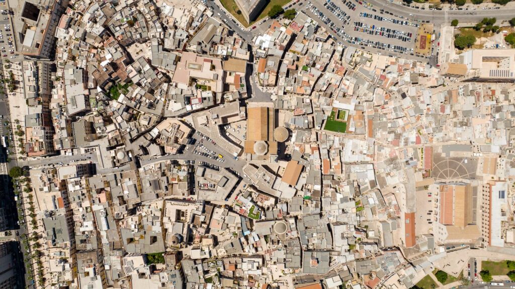 Aerial top-down view of a dense old town with many rooftops and winding streets