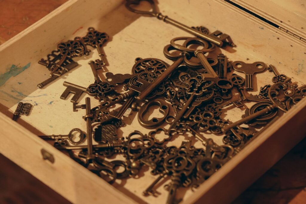 Pile of ornate vintage keys inside an open wooden box
