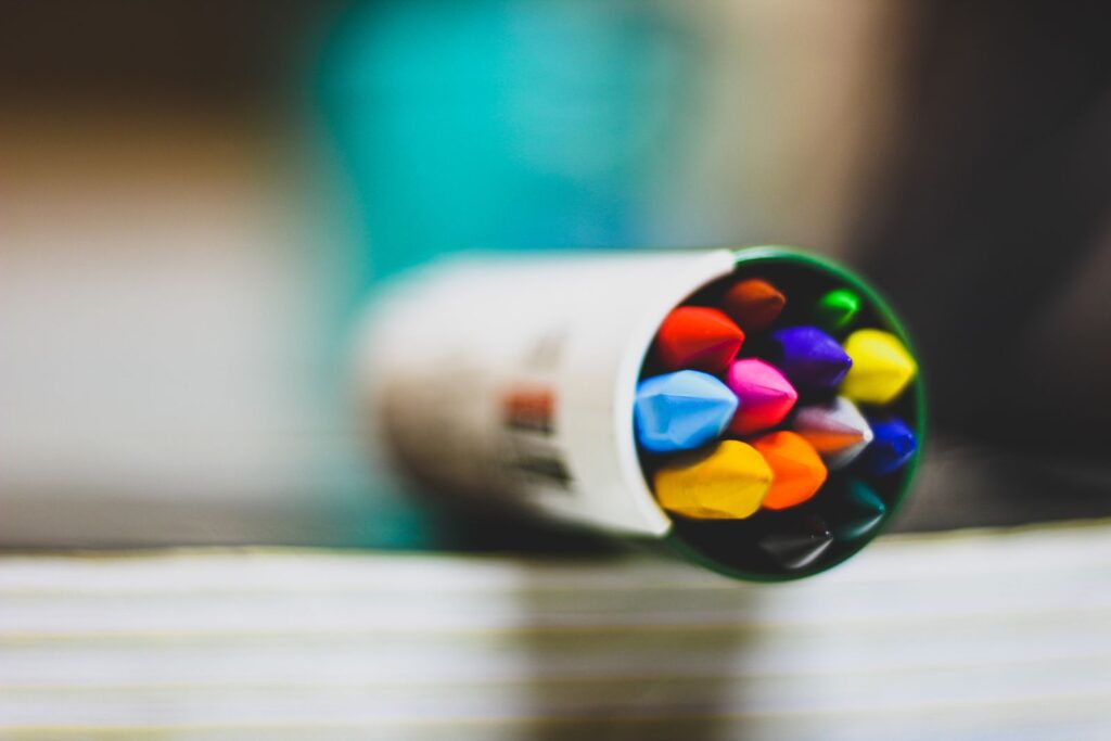 Colorful crayons packed inside a white tube, seen up close with a soft blurred background